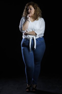 Plus size fashion model, fat woman in denim clothes and white shirt on black background, overweight female body