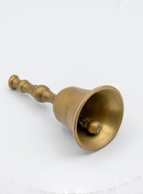 Beyaz üzerine küçük bir bronz çanın fotoğrafı