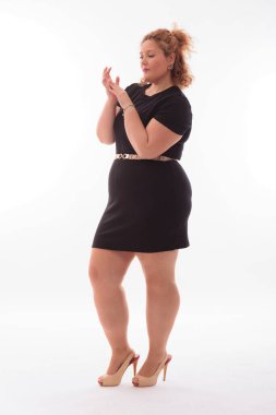 Stüdyoda sarı saçlı, kıvrımlı, hoş bir genç kadın.