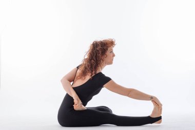 Stüdyoda, beyaz arka planda, güzel bir kadınla huzurlu bir yoga pratiği.