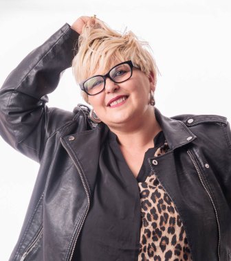 Beyaz arka planda deri ceket giyen gülümseyen sarışın kadının stüdyo portresi.