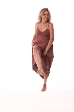 Gözlüklü, çıplak ayakla dans eden, elbisesini kaldıran, özgürlüğün ve özgüvenin keyfini çıkaran, beyaz bir arka planda yaşayan son sınıf öğrencisi.