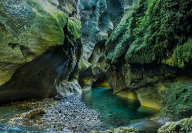 The turquoise water of the river flowing the lichen and moss covered chasm walls in the beautiful  Patuna Chasm