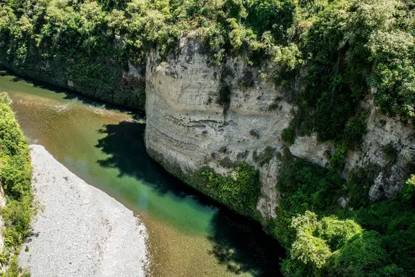 Rangitikei Nehri 'nin turkuaz suyu Yeni Zelanda' nın Manawatu Bölgesi 'ndeki kanyonlarda ve geçitlerde yüksek uçurumlardan ve kaya duvarlarından akıyor.