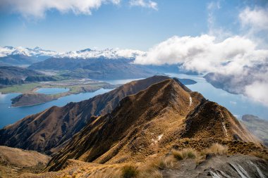 Wanaka Gölü koylarının muhteşem manzarası ve Roys Tepesi dağ yolundan gelen kar kaplı Güney Alpleri. 