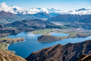 Wanaka Gölü koylarının muhteşem manzarası ve Roys Tepesi dağ yolundan gelen kar kaplı Güney Alpleri. 