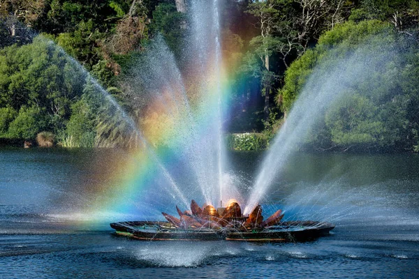 A rainbow caught in the mist and spray over the modern art fountain  in the central city lake
