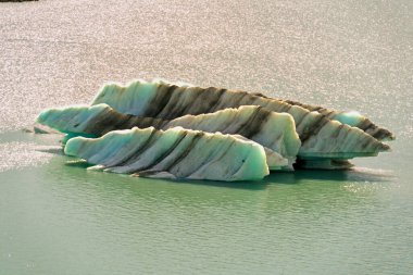 Tasman Gölü 'ndeki (Aoraki Cook Dağı Ulusal Parkı) 30-50 metre uzunluğundaki buzdağına yaklaşın. inanılmaz katmanlı dokular ve renkler