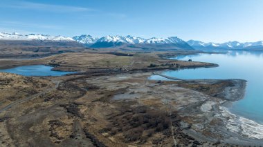 Tekapo Gölü 'nün Godleys' ten Glenmore İstasyonu 'na giden uzun yolda çakıl yolu manzarası