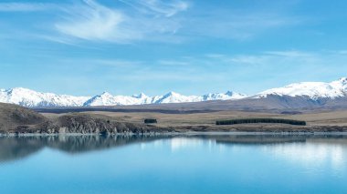 İHA dağı ve tarım ülkesi Roundhill Kayak alanı yakınlarındaki Tekapo Gölü kıyılarına bakıyor