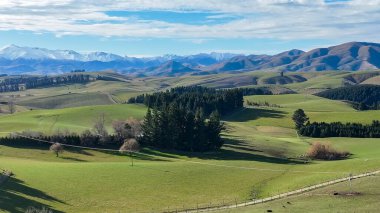 Dağ sıralarının panoramik hava manzaraları ve verimli yeşil kırsal tarım ekinleri ve otlak kırsal alanlarla kaplı tepeler ve vadiler