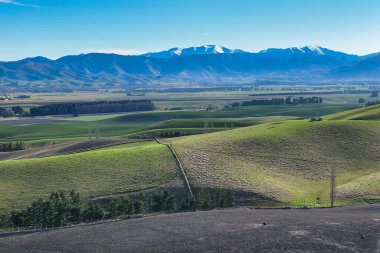 Dağ sıralarının panoramik hava manzaraları ve verimli yeşil kırsal tarım ekinleri ve otlak kırsal alanlarla kaplı tepeler ve vadiler