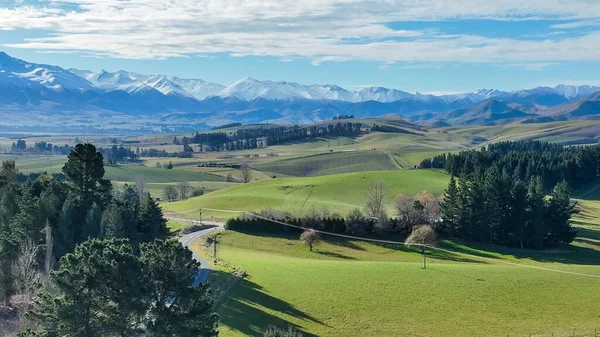 Dağ sıralarının panoramik hava manzaraları ve verimli yeşil kırsal tarım ekinleri ve otlak kırsal alanlarla kaplı tepeler ve vadiler