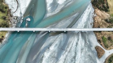 Örgülü Dart nehrinin hava aracı manzarası Güney Alp dağlarıyla çevrili kırsal bir vadiden Glenorchy yakınlarındaki Wakatipu Gölü 'ne akıyor.