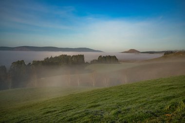 Berwick 'in kırsal tepeleri (Dunedin' in güneybatısı), soğuk ve soğuk bir günde, vadilerde sislerin ve sislerin aktığı,