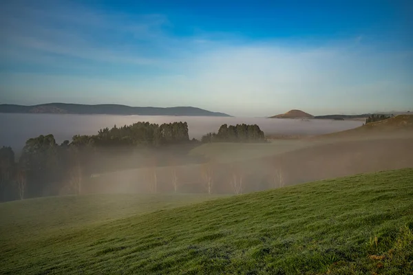 Berwick 'in kırsal tepeleri (Dunedin' in güneybatısı), soğuk ve soğuk bir günde, vadilerde sislerin ve sislerin aktığı,