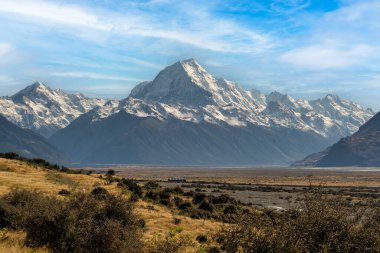 Cook Dağı yolu Aoraki Dağı Ulusal Parkı 'ndaki kar tepeli alp dağlarına doğru gidiyor.