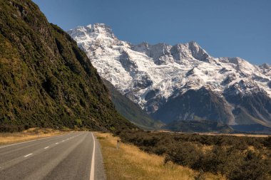 Cook Dağı yolu Aoraki Dağı Ulusal Parkı 'ndaki kar tepeli alp dağlarına doğru gidiyor.