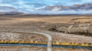 Ashburton dağlarının insansız hava aracı görüntüsü. Heron Gölü 'ne giden kurak araziden akan bir nehir.