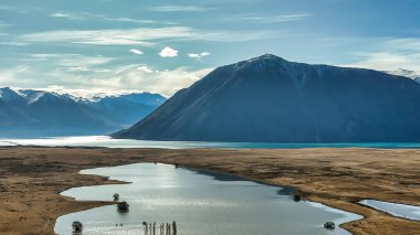 The way to Lake Ohau and the southern alps through alpine grasses and tundra terrain clipart