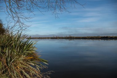 Güneşin doğuşunda Taieri nehri bir haliç haline gelir ve sabah erkenden Otokai 'deki Taieri nehri üzerindeki tarihi Henley asma köprüsü.