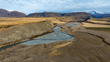 Heron Gölü 'ne giden kuru arazide nehir ve göl olan Ashburton dağlarının insansız hava aracı manzarası.