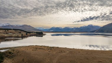 Ashburton dağlarının insansız hava aracı manzarası Heron Gölü 'ne giden kuru arazide bir nehir ve bir göl.