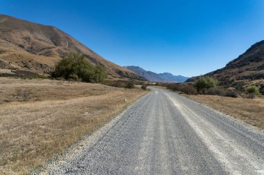 Dağ sıralarıyla çevrili Canterbury NZ 'deki Ahuriri koruma vadisindeki aşırı kurak tarlalar.