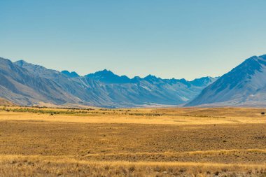 Dağ sıralarıyla çevrili Canterbury NZ 'deki Ahuriri koruma vadisindeki aşırı kurak tarlalar.