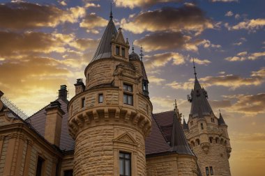 Towers of old historical romantic fairy-tale Moszna castle and palace outdoors, closeup. Poland. Famous tourist landmar