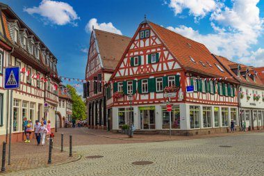 23.07.2023 Antik Seligenstadt kasabası, Offenbach bölgesi - Almanya 'nın en eski şehirlerinden biri. Tarihi şehrin sokaklarındaki dükkanları ve kafeleri olan turistler. Renkli yarı keresteli evler. Ünlü turistik mekan ve turistik mekan