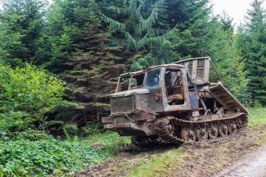 Kirli bir orman yolunda dozer, orman sürüngeni traktörü. Ukrayna 'daki Karpat dağında kereste hasadı. Ağaç kesme ekipmanları, ağır ekipman