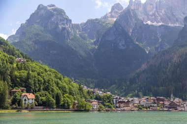Dağları çevreleyen Alleghe göl ve köy manzarası. Lago di Alleghe, Belluno, İtalya. Dolomitler dağları. Ünlü turizm beldesi
