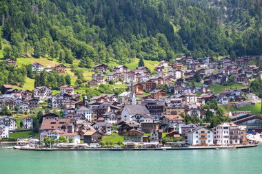Dağları çevreleyen Alleghe göl ve köy manzarası. Lago di Alleghe, Belluno, İtalya. Dolomitler dağları. Ünlü turizm beldesi