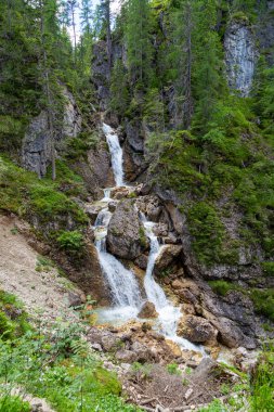 Federa Vadisi yürüyüşü. Cortina d'Ampezzo . Dolomitler. İtalya. Resimli şelaleler ve yeşil orman dağ geçidinde kayalar arasındaki yaya köprüleri. Turizm beldesi
