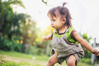 Çocuk akşamları çimlerin üzerinde oturuyor.