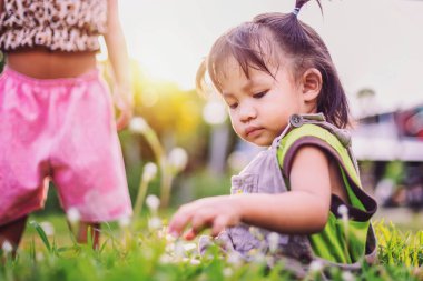 Çocuk akşamları çimlerin üzerinde oturuyor.