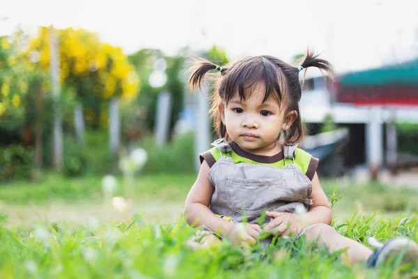 stock image child sitting on the grass in the evening