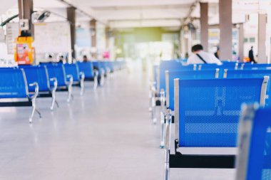 Mavi sandalyeler düzenli bir şekilde dizilmiş. Yolcu bırakma istasyonunda.