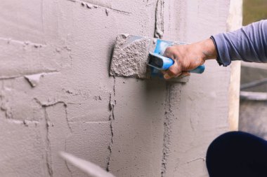 Beton alçıcılar endüstriyel işçilerin arka plan duvarlarını alçılama araçlarıyla donatmak için.