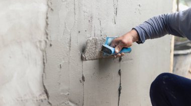 Beton alçıcılar endüstriyel işçilerin arka plan duvarlarını alçılama araçlarıyla donatmak için.