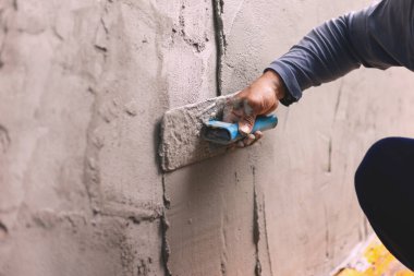Beton alçıcılar endüstriyel işçilerin arka plan duvarlarını alçılama araçlarıyla donatmak için.