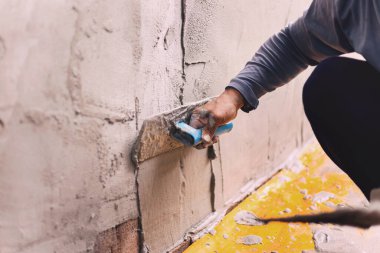 Beton alçıcılar endüstriyel işçilerin arka plan duvarlarını alçılama araçlarıyla donatmak için.
