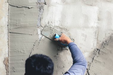 Beton alçıcılar endüstriyel işçilerin arka plan duvarlarını alçılama araçlarıyla donatmak için.