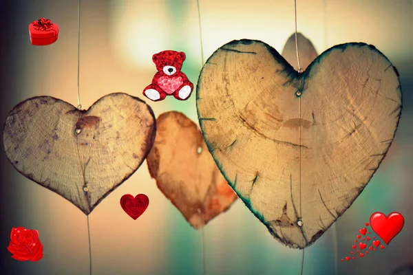 Valentine\'s day on a beautiful background with hanging hearts made of wood, around with a heart and flowers