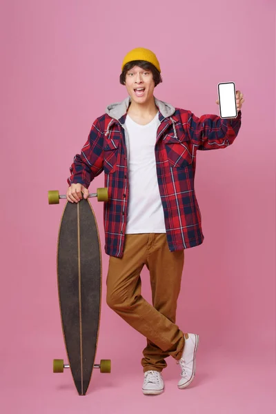 Szczęśliwy Nastolatek Trzymać Smartfona Makiety Biały Ekran Oprzeć Się Longboard — Zdjęcie stockowe