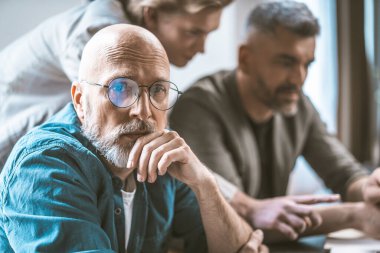Ofis ortamında iş arkadaşları olan bilge, olgun bir adam beyin fırtınası yapıyor. Kameraya kendinden emin bakışlarla profesyonelliği ve liderliği gösteriyorlar. Yüksek kalite fotoğraf