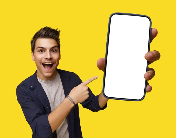 Uśmiechnięty Młody Przystojny Mężczyzna Trzymający Telefon Komórkowy Białym Ekranem Oferujący — Zdjęcie stockowe