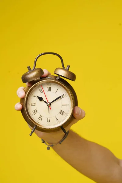 Relógio Despertador Mão Homem Isolado Sobre Fundo Amarelo Vibrante Imagem — Fotografia de Stock