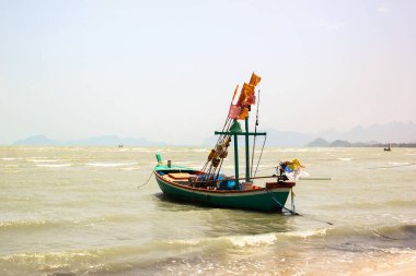 Denizdeki yerel balıkçı teknesi Gün doğumunda dramatik bulutlar.